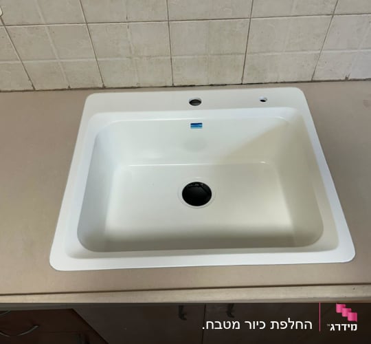 כיור לבן משובץ בשיש בהיר במטבח